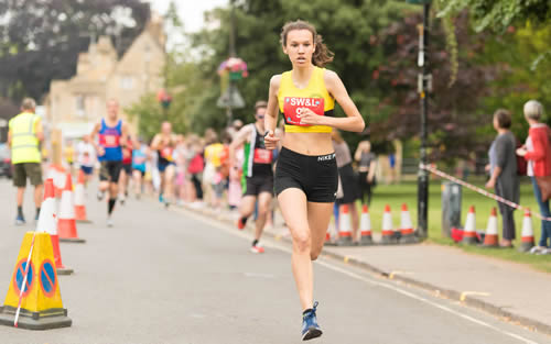 First lady at the 2019 Bourton One Mile Challenge, Emily Field running for Stratford AC - Bourton 1 Mile 13-07-2019
