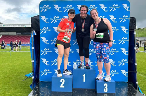 Annie taking advantage of the podium for a photo at the Northampton 10k - 26th May 2024. Click on image for a larger version